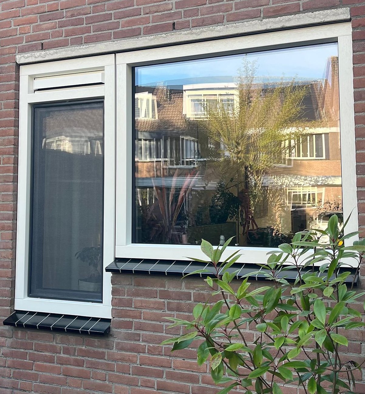 Witte kunststof kozijnen in de gevel van een woning